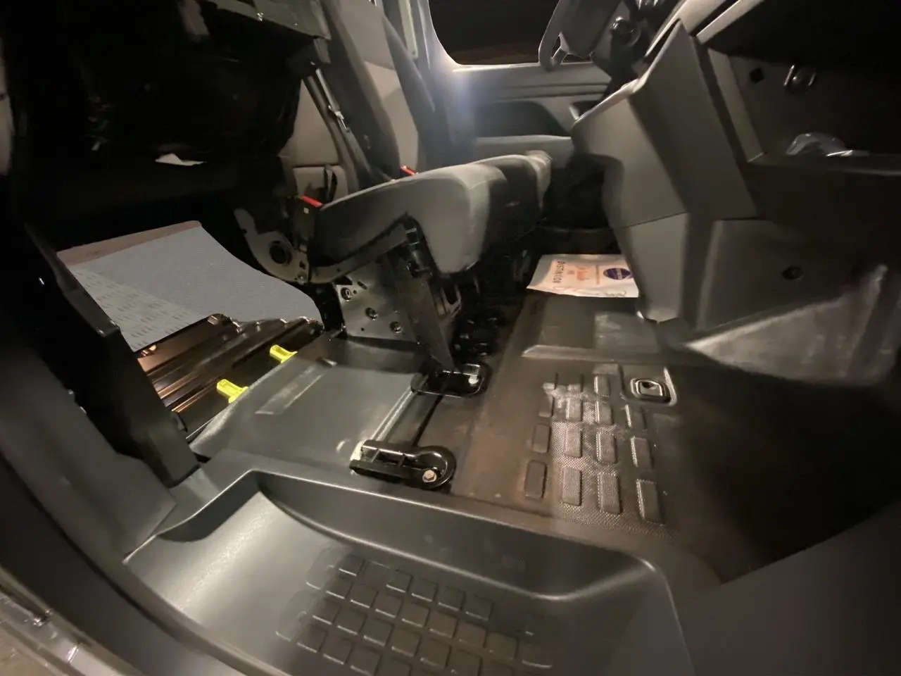 Vue intérieure côté passager du Citroën Jumpy Fourgon 2024, montrant le plancher et la banquette modulable en tissu noir-gris.