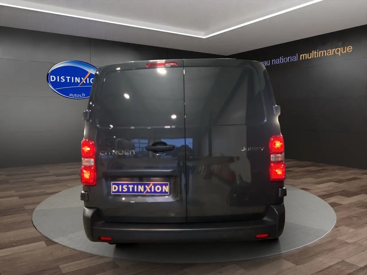 Vue arrière du Citroën Jumpy Fourgon gris platinium dans un showroom avec portes battantes fermées.