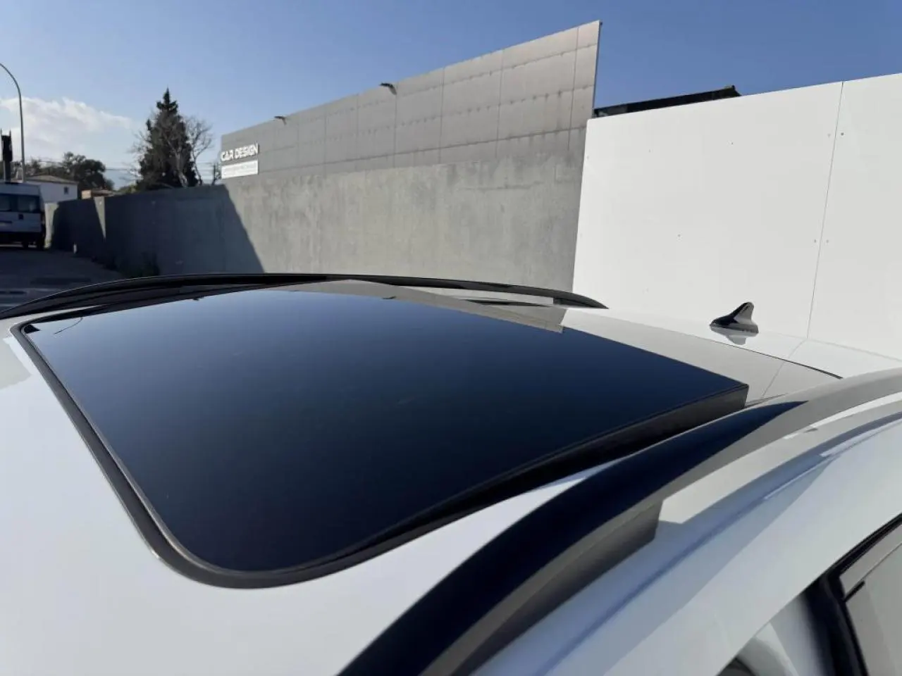 Vue rapprochée du toit ouvrant panoramique noir sur un CUPRA Formentor blanc nacré avec rails de toit noirs.