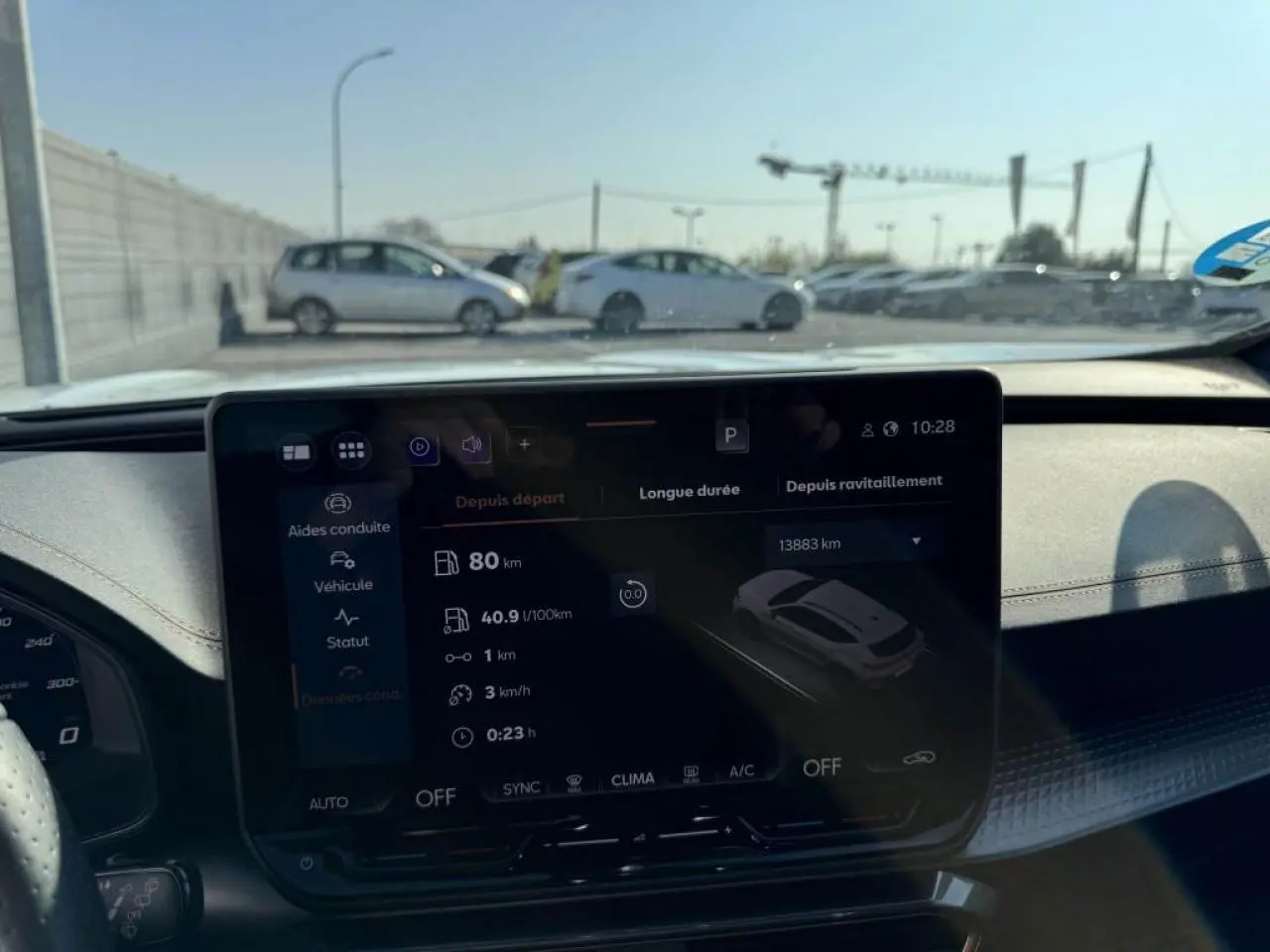 Vue intérieure centrée sur l’écran tactile du tableau de bord du CUPRA Formentor blanc nacré avec toit noir, affichant les données de conduite.