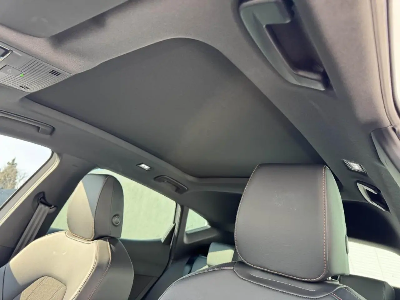 Vue intérieure du toit ouvrant panoramique noir et des sièges avant en cuir du CUPRA Formentor blanc nacré.