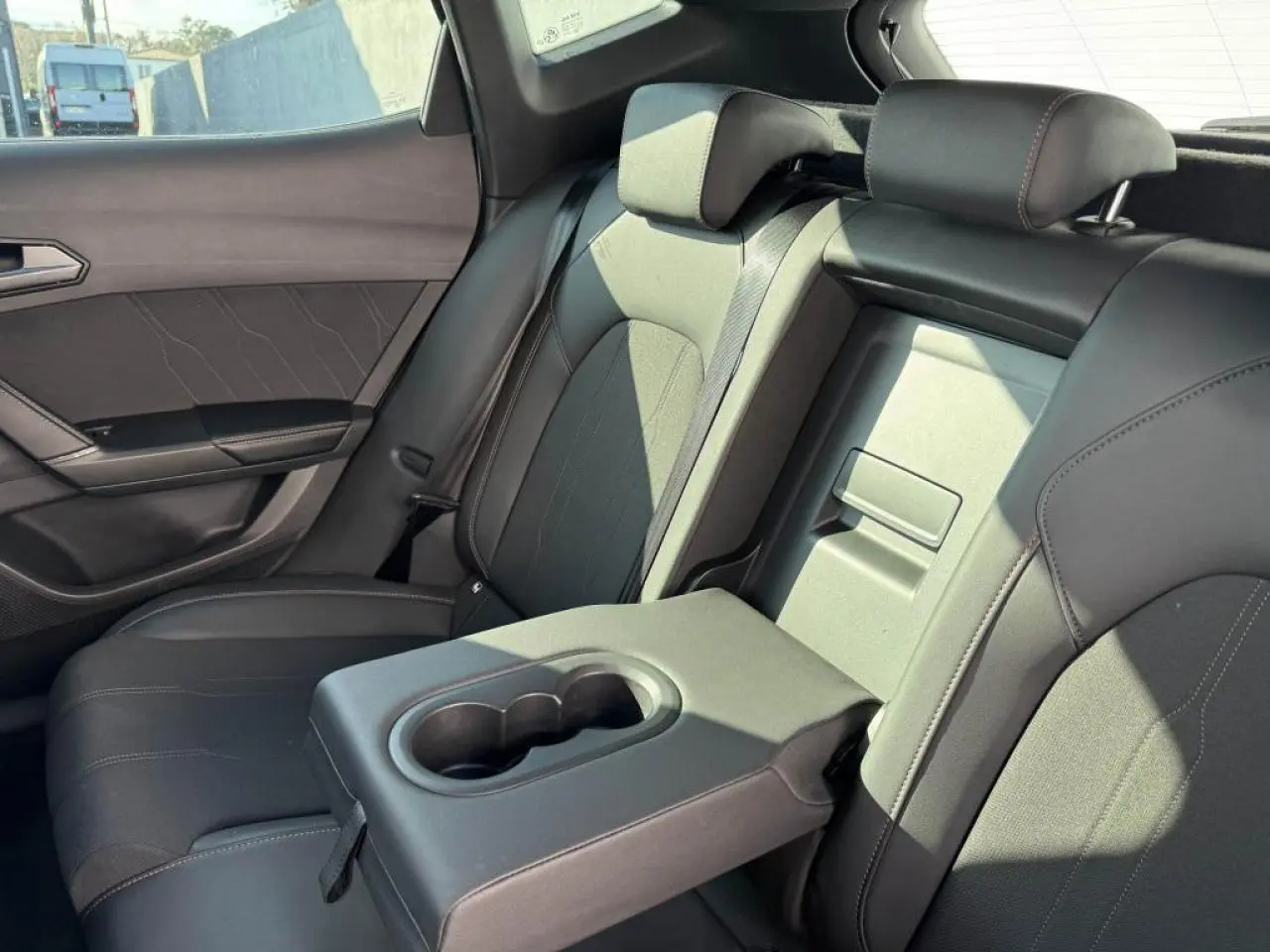 Vue intérieure côté droit sur la banquette arrière noire du CUPRA Formentor avec accoudoir central et porte-gobelets.