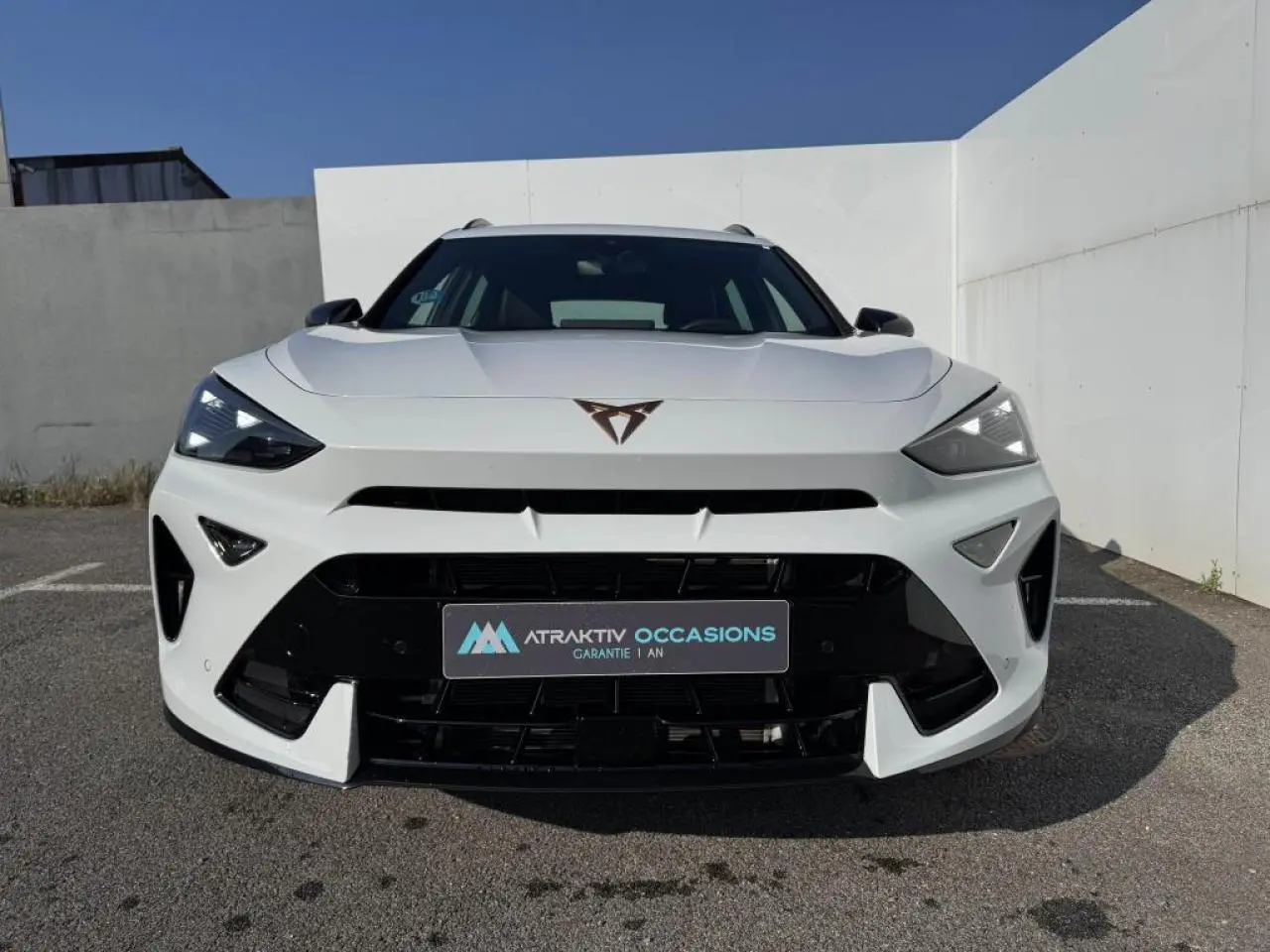 Vue avant d'une CUPRA Formentor blanc nacré avec toit noir, signature lumineuse Tri-LED et calandre noire brillante.