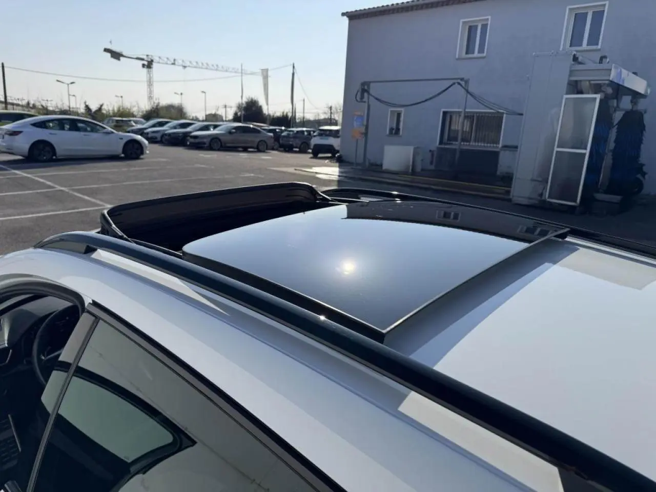 Vue plongeante sur le toit ouvrant panoramique noir du CUPRA Formentor blanc nacré avec rails de toit noirs.