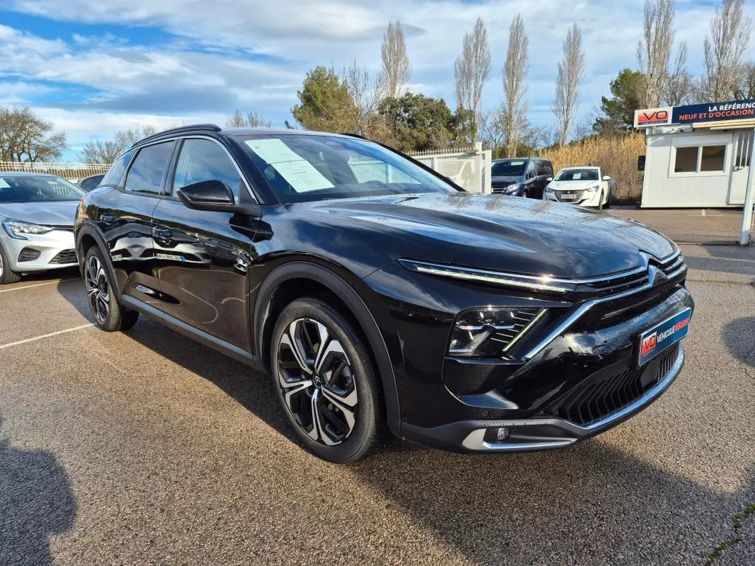 Citroën C5 X noir vue 3/4 avant droit, jantes alliage 19 pouces et calandre distinctive au soleil.