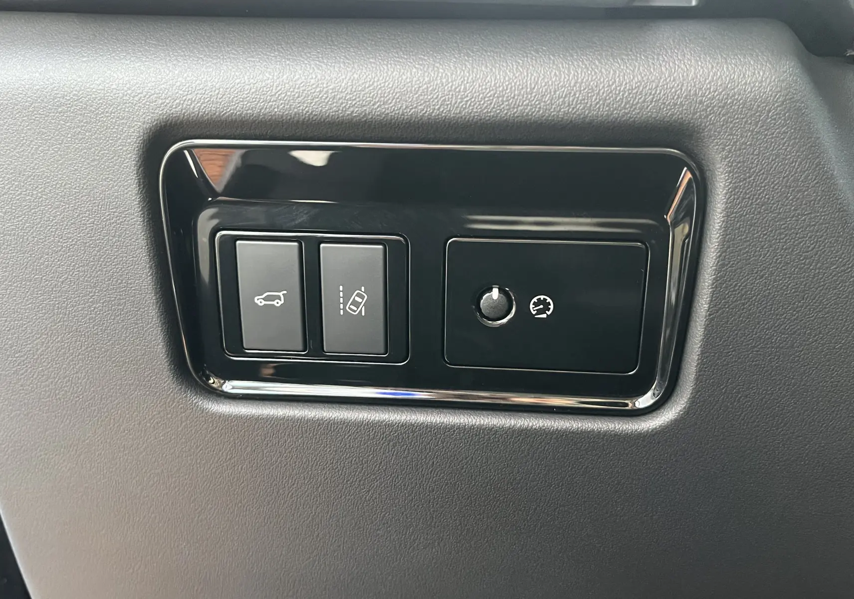 Gros plan sur les commandes noires encastrées dans la planche de bord grise du Jaguar F-PACE blanc 2018.