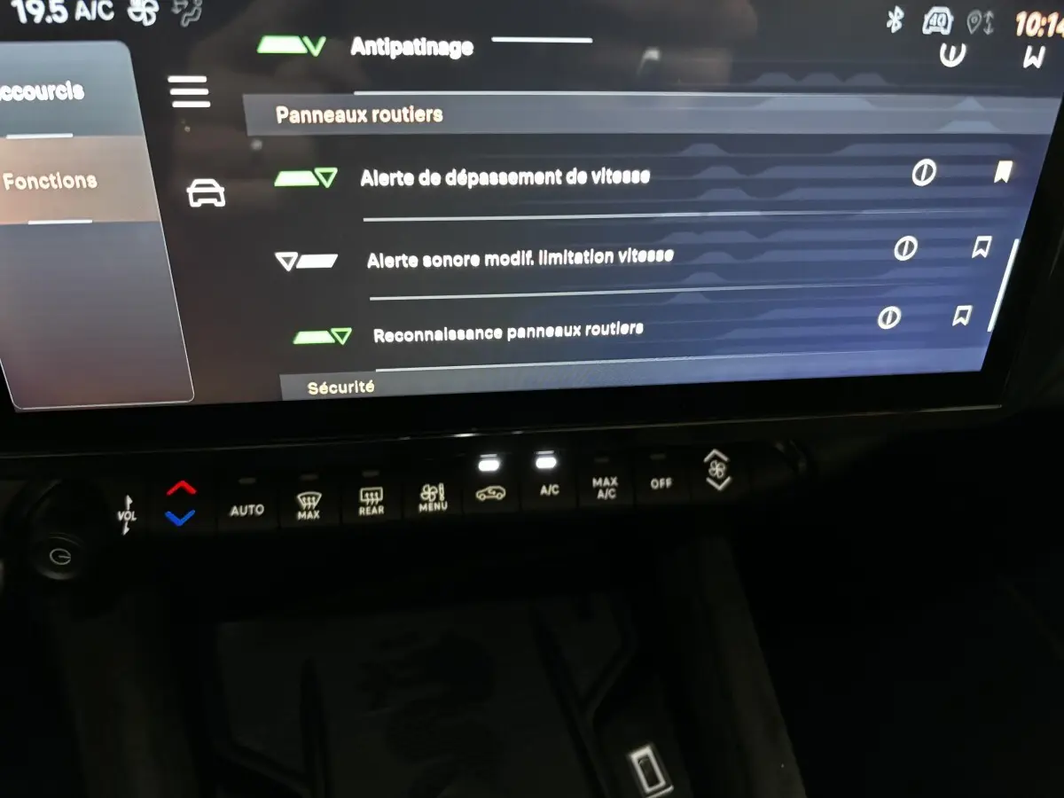 Écran tactile central affichant les options de sécurité et climatisation avec commandes tactiles dans l'habitacle sombre d'Alfa Romeo Junior rouge.
