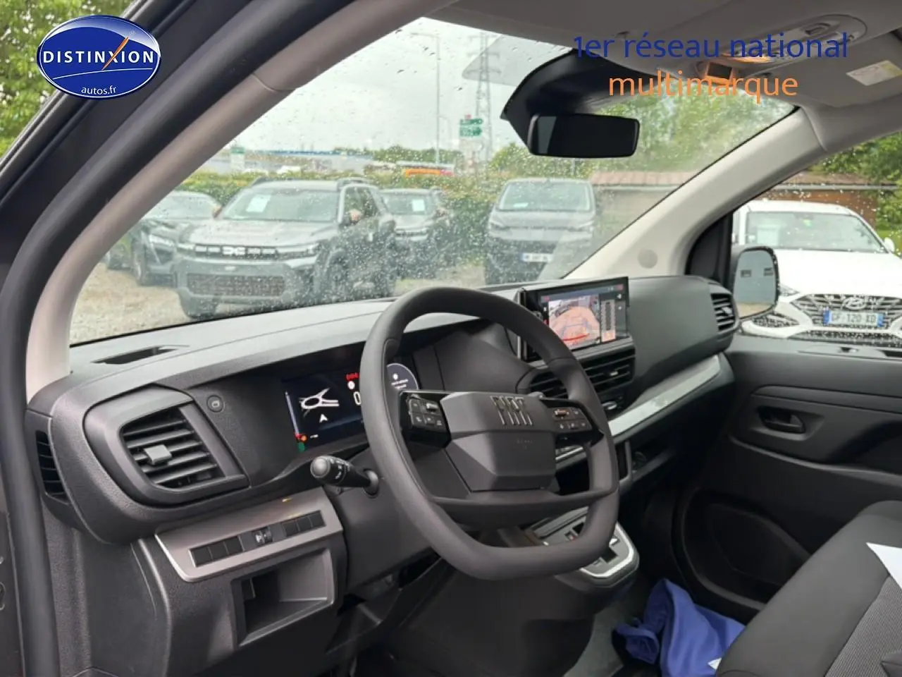 Vue intérieure côté conducteur du Fiat Scudo Combi gris titane, avec tableau de bord numérique et écran tactile central.