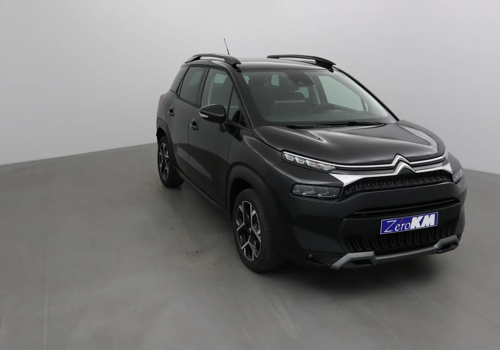 Citroën C3 Aircross noir vue 3/4 avant droit, avec barres de toit et jantes alliage 17 pouces.