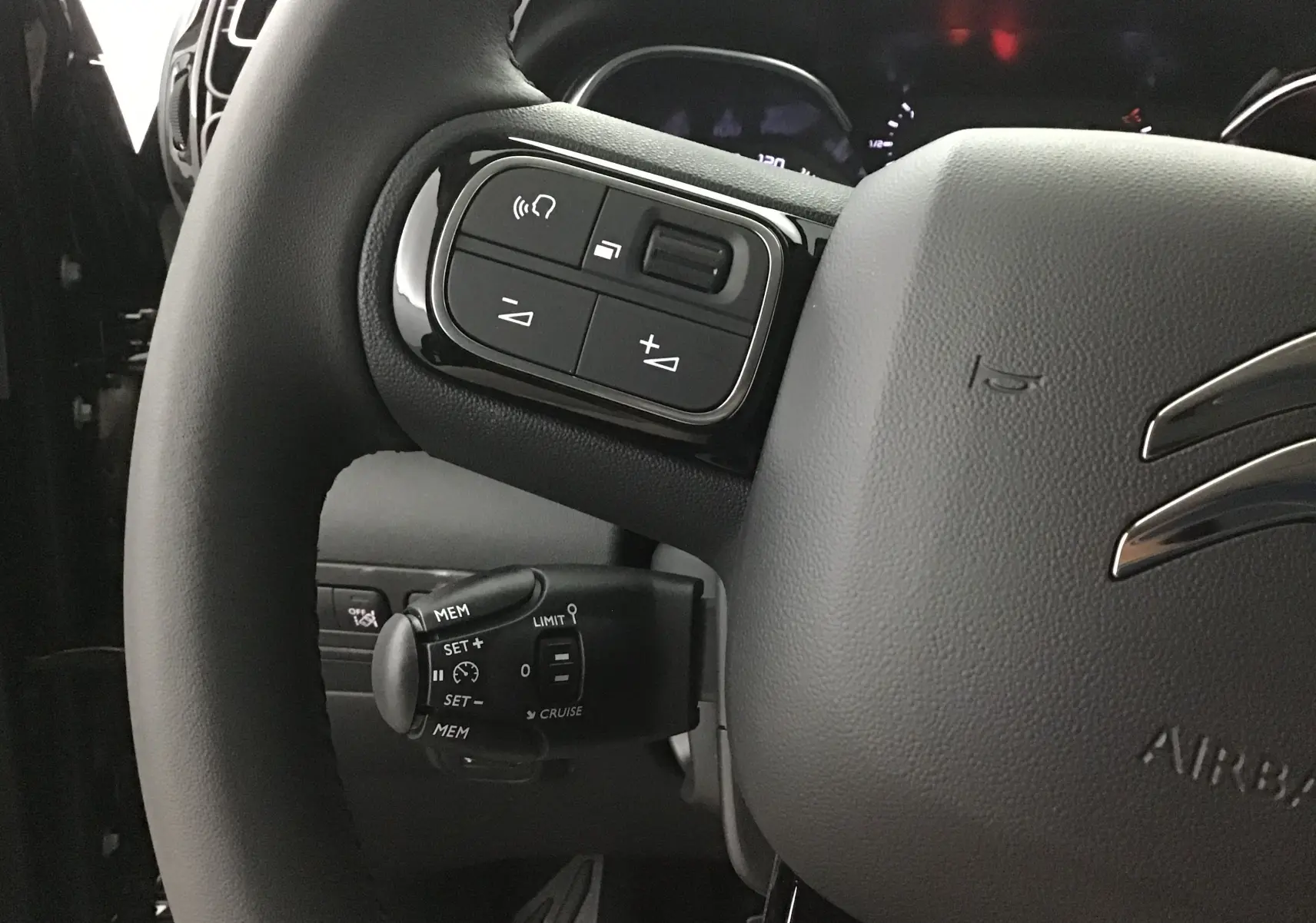 Gros plan sur le volant noir du Citroën C3 Aircross 2024, mettant en valeur les commandes intégrées à gauche.