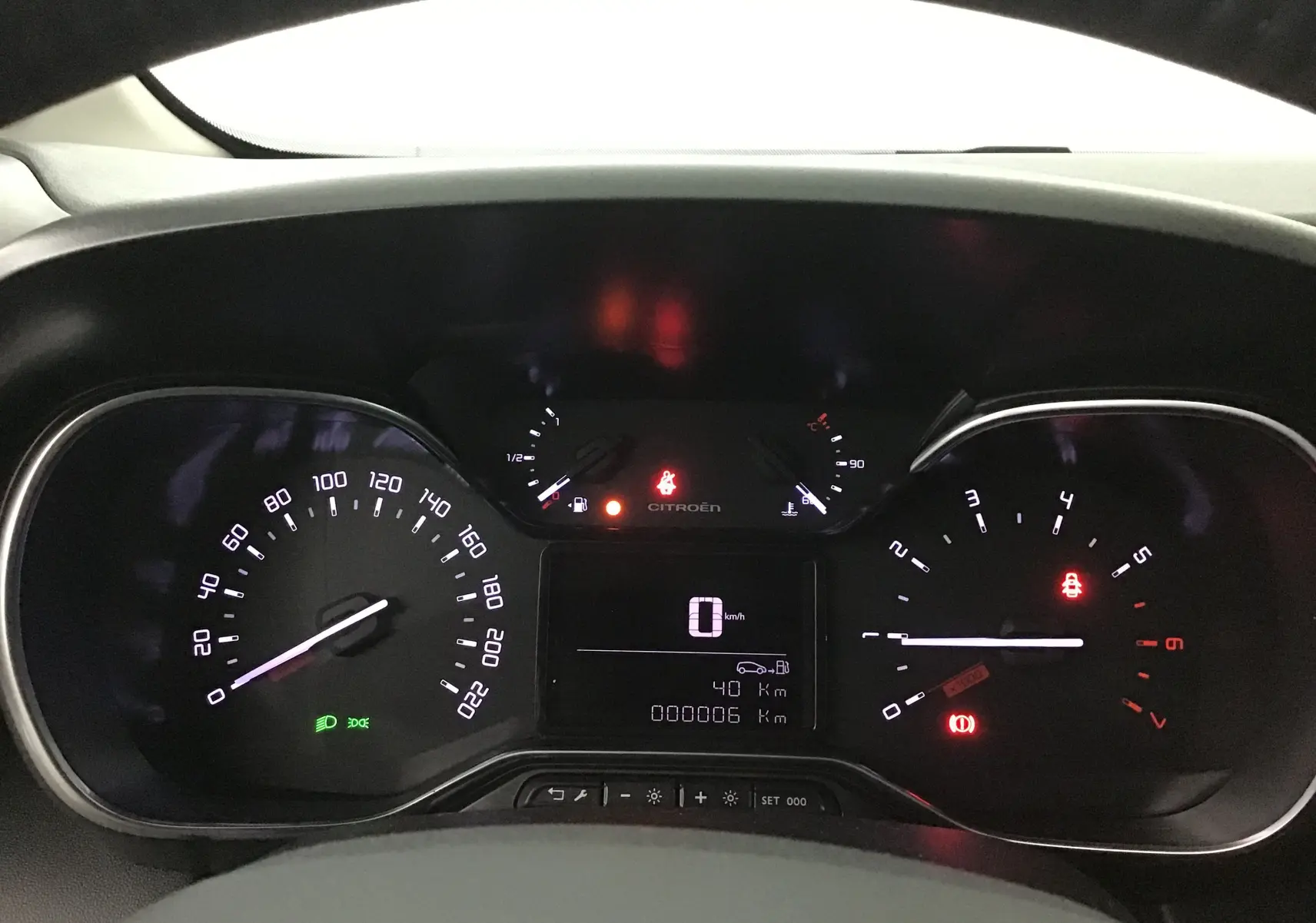 Tableau de bord éclairé d'une Citroën C3 Aircross 2024, affichant vitesse, compte-tours et jauges, vue frontale rapprochée.