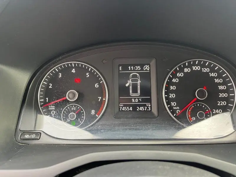 Tableau de bord du Volkswagen Caddy Van blanc 2016, affichant compte-tours, vitesse et écran multifonction central.