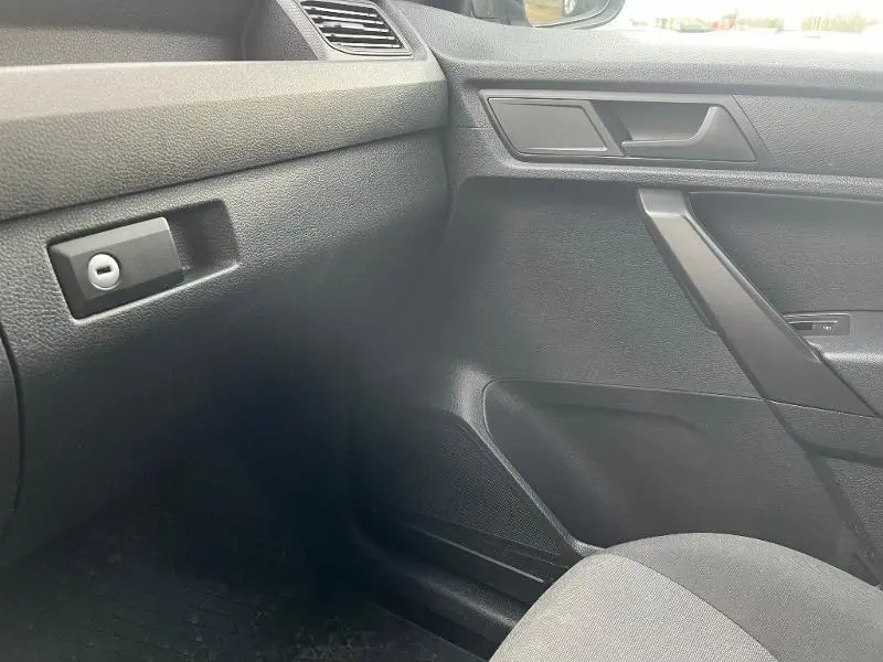 Intérieur côté passager du Volkswagen Caddy Van blanc 2016, avec tableau de bord et porte en tissu noir Austin.