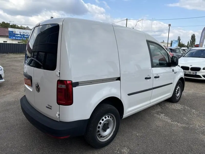 Vue 3/4 arrière droite d'un Volkswagen Caddy Van blanc Candy avec portes arrière vitrées et jantes acier.