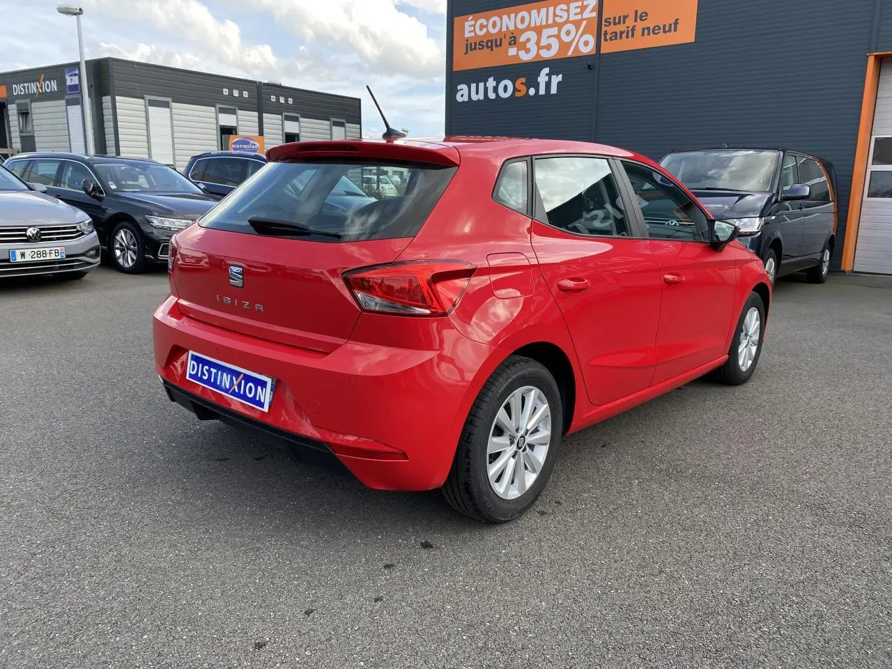 Vue 3/4 arrière droite d'une SEAT IBIZA rouge pur 2021 avec jantes alliage 15'' sur parking extérieur.