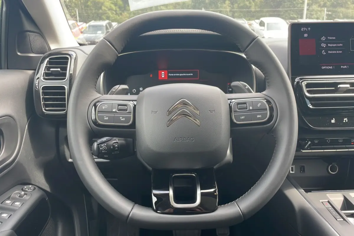 Vue centrée sur le volant Citroën C5 Aircross Hybrid 2025, avec tableau de bord numérique et écran tactile visible.