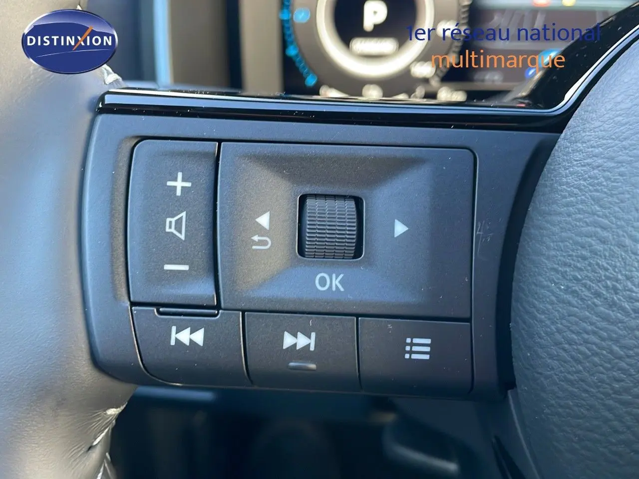 Gros plan sur les commandes multifonctions du volant côté gauche du Nissan Qashqai blanc nacré 2025 finition N-Design.