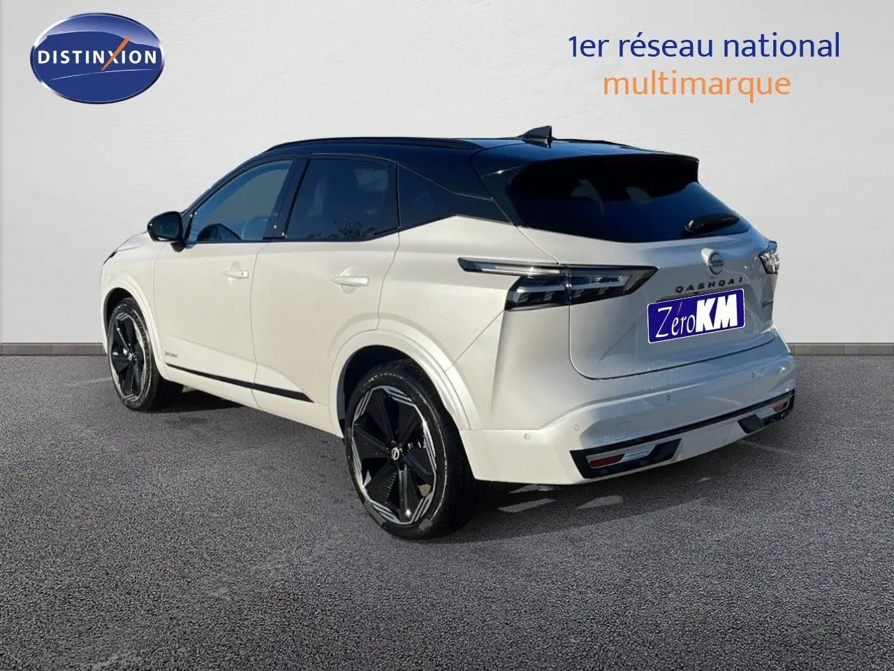 Vue 3/4 arrière droite d'un Nissan Qashqai blanc nacré avec toit noir et jantes noires distinctives.