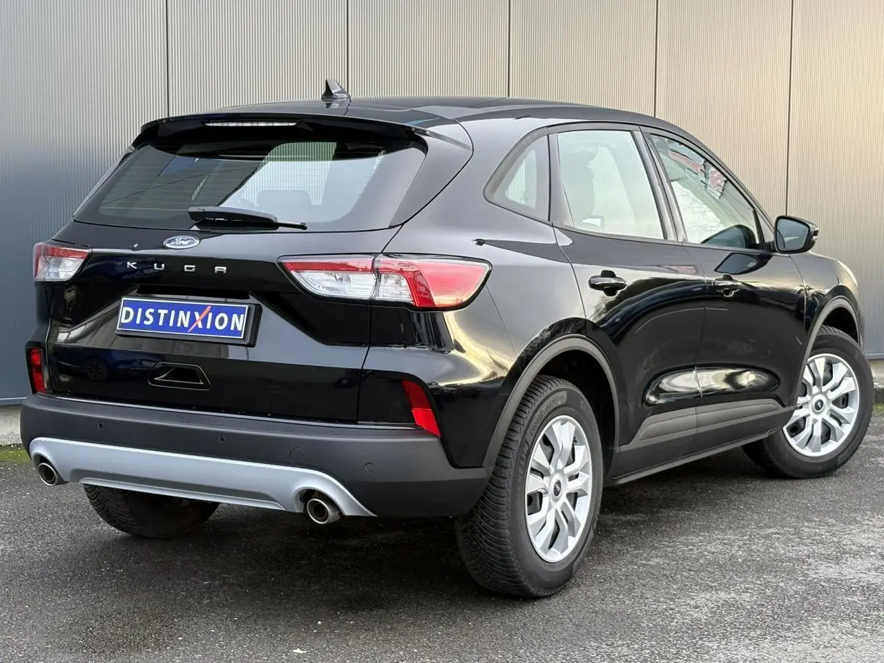 Vue 3/4 arrière droite du Ford Kuga noir Obsidien 2024 avec attelage rétractable et feux arrière LED.