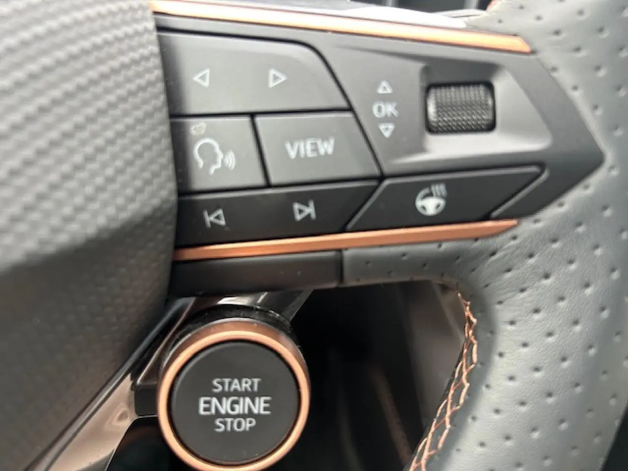 Détail du bouton Start Engine Stop et commandes sur le volant perforé avec surpiqûres cuivrées du CUPRA Formentor gris Fiord.
