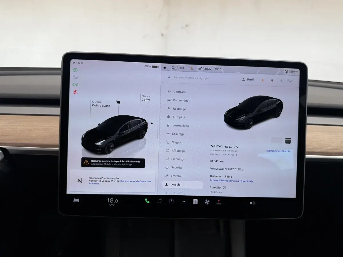 Écran tactile central affichant les réglages d'une Tesla Model 3 noire, vue intérieure du tableau de bord.