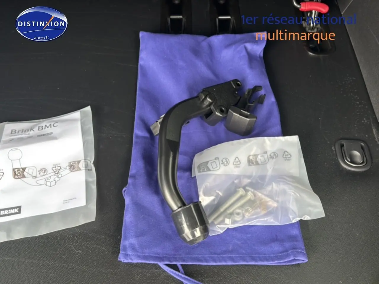 Vue intérieure du coffre d’un FIAT Scudo Combi noir 2026, montrant un attelage démontable et ses accessoires posés sur un tissu bleu.