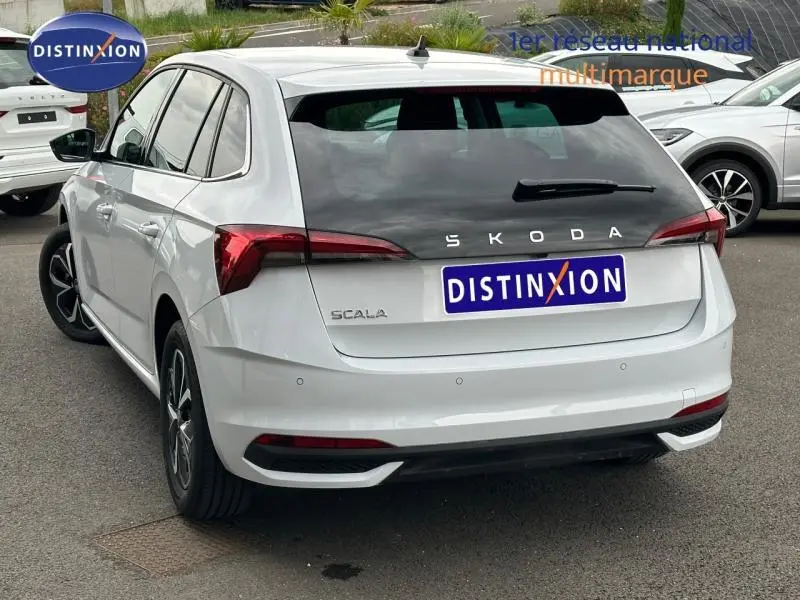 Vue 3/4 arrière droite d'une Skoda Scala blanche Cristal avec feux arrière LED et jantes alliage noir et argent.