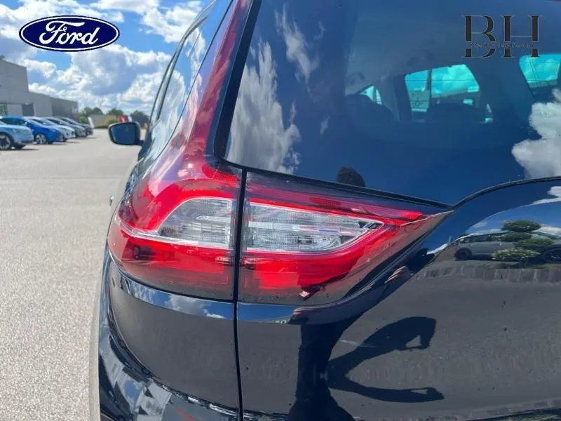 Feu arrière droit du Renault Grand Scénic noir étoilé 2021, avec vitre arrière surteintée et reflet du ciel.