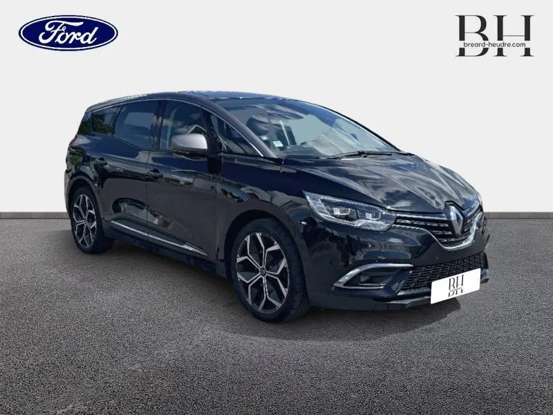 Renault Grand Scenic noir étoilé en 3/4 avant droit, avec jantes alliage 20 pouces et feux LED distinctifs.