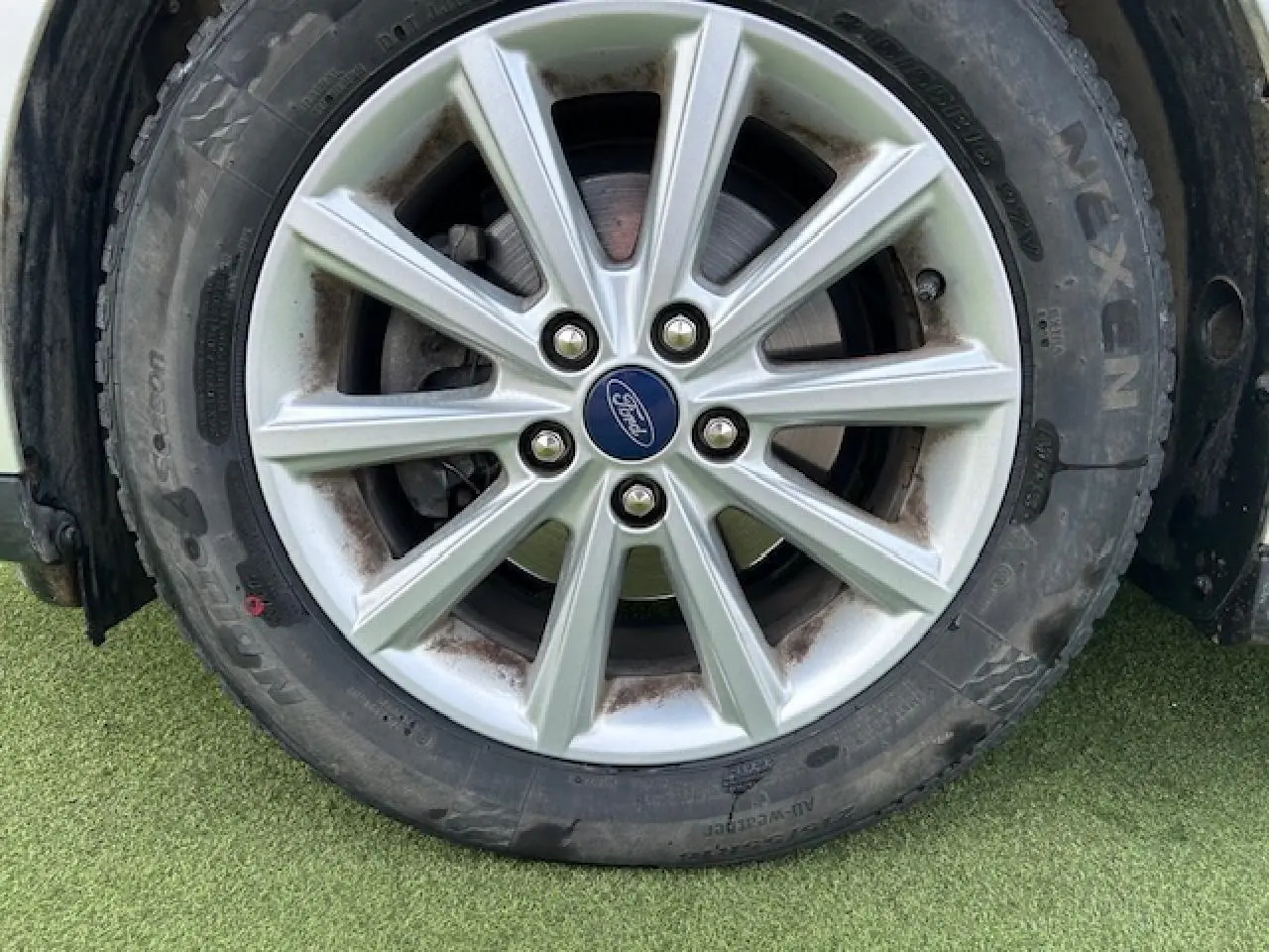 Gros plan sur la jante alliage 16 pouces 10 branches argentée avec logo Ford au centre sur pneu toutes saisons.