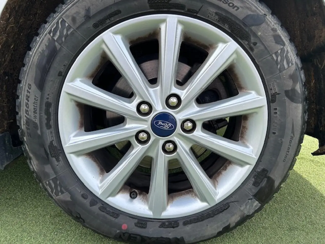 Gros plan sur la jante alliage 16 pouces à 10 branches argentée avec pneu toutes saisons sur Ford C-MAX gris clair.