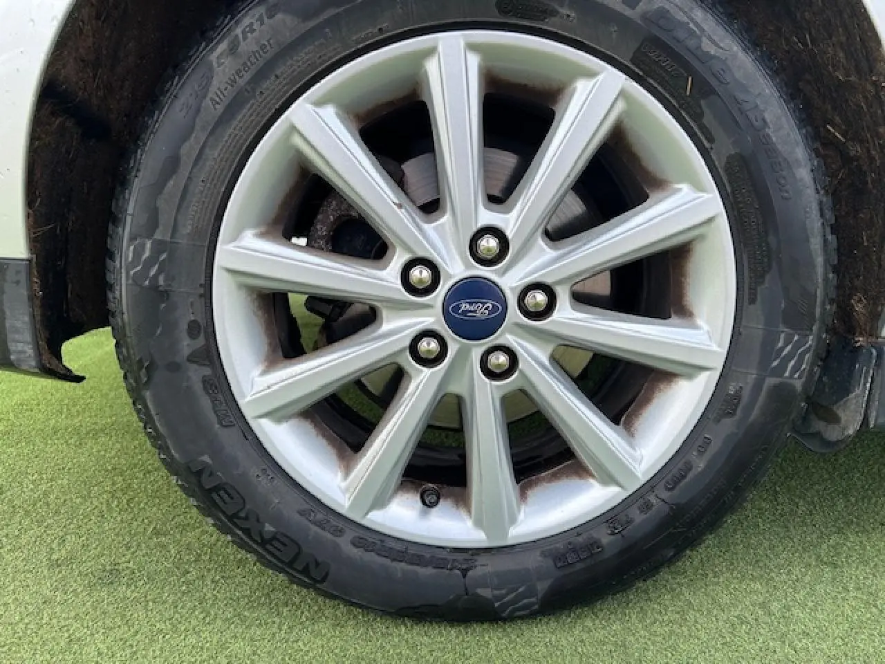 Gros plan sur la jante alliage 16 pouces à 10 branches avec logo Ford sur pneu toutes saisons d’un Ford C-MAX gris clair.