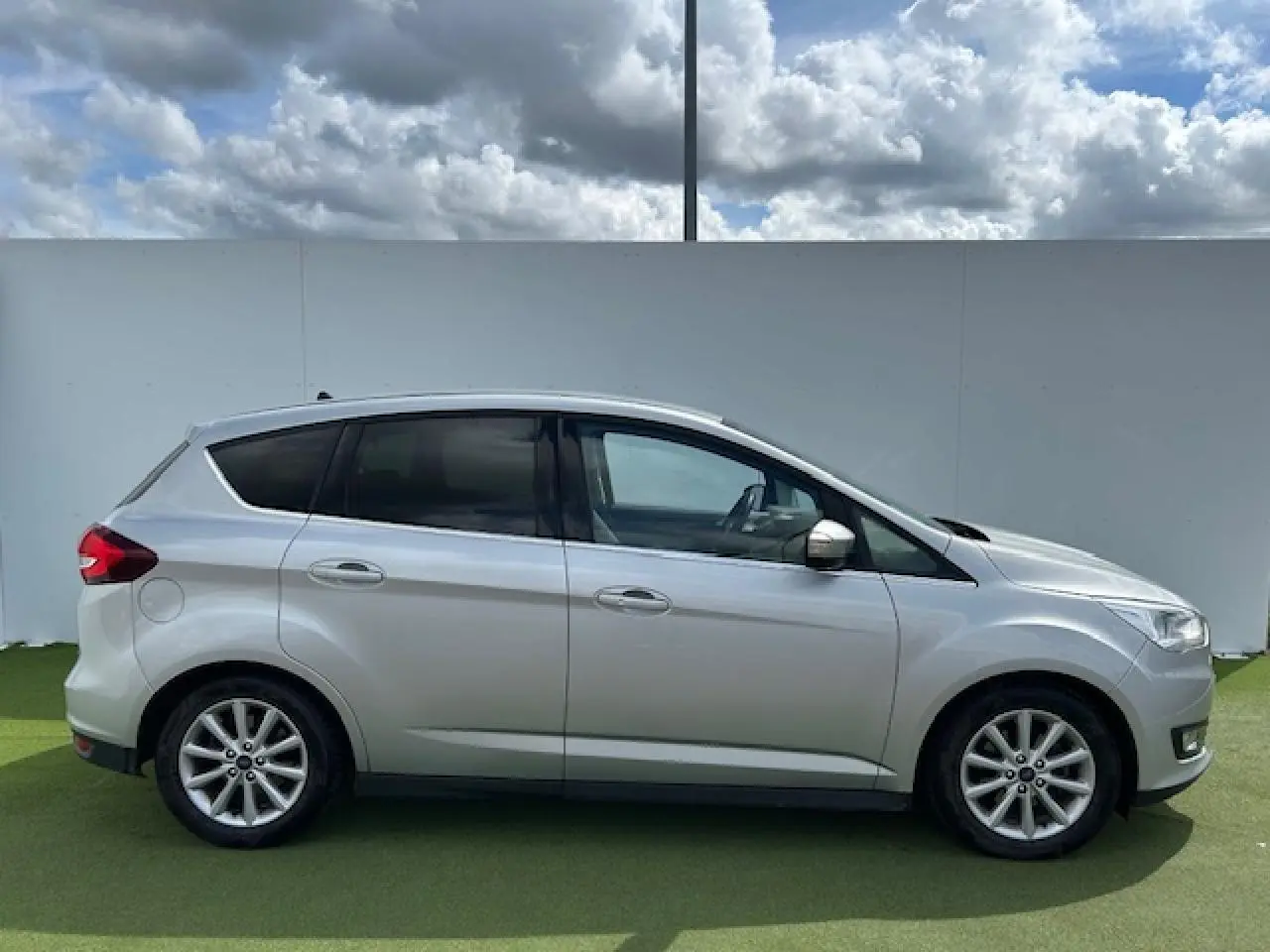 Vue latérale droite d'une Ford C-MAX gris clair métallisé avec vitres arrière surteintées et jantes alliage 16 pouces.