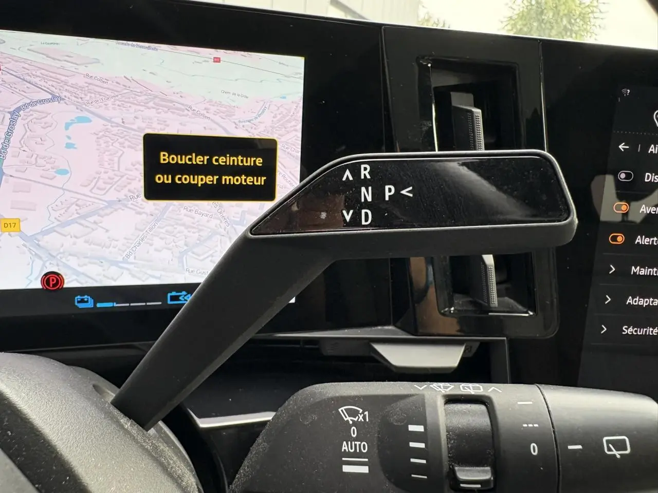 Gros plan sur le levier de vitesses automatique noir et l'écran tactile affichant la navigation dans l'habitacle du Renault Espace VI bleu nuit.