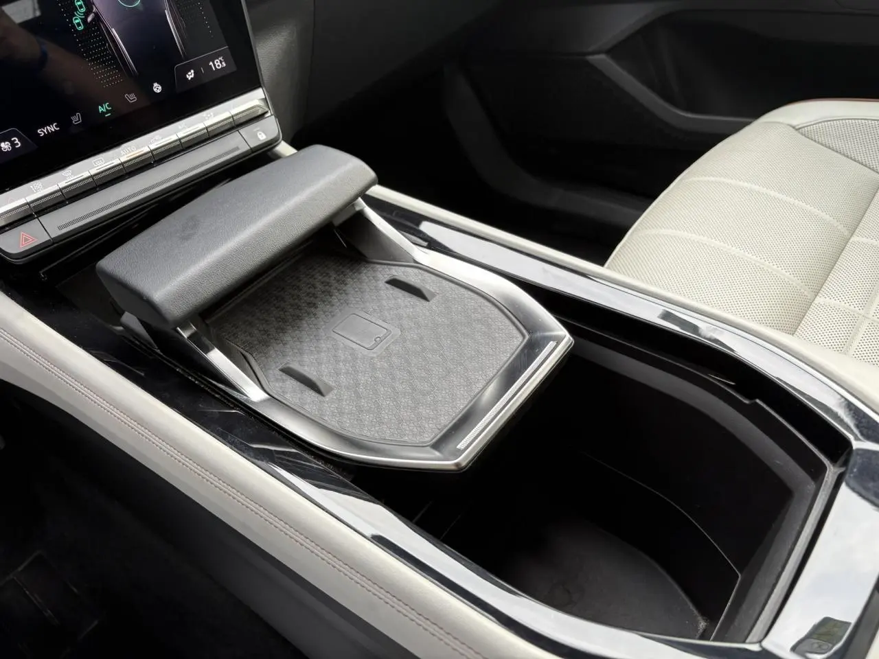 Gros plan sur la console centrale noire et le siège avant cuir gris sable clair perforé du Renault Espace VI 6 E-Tech.