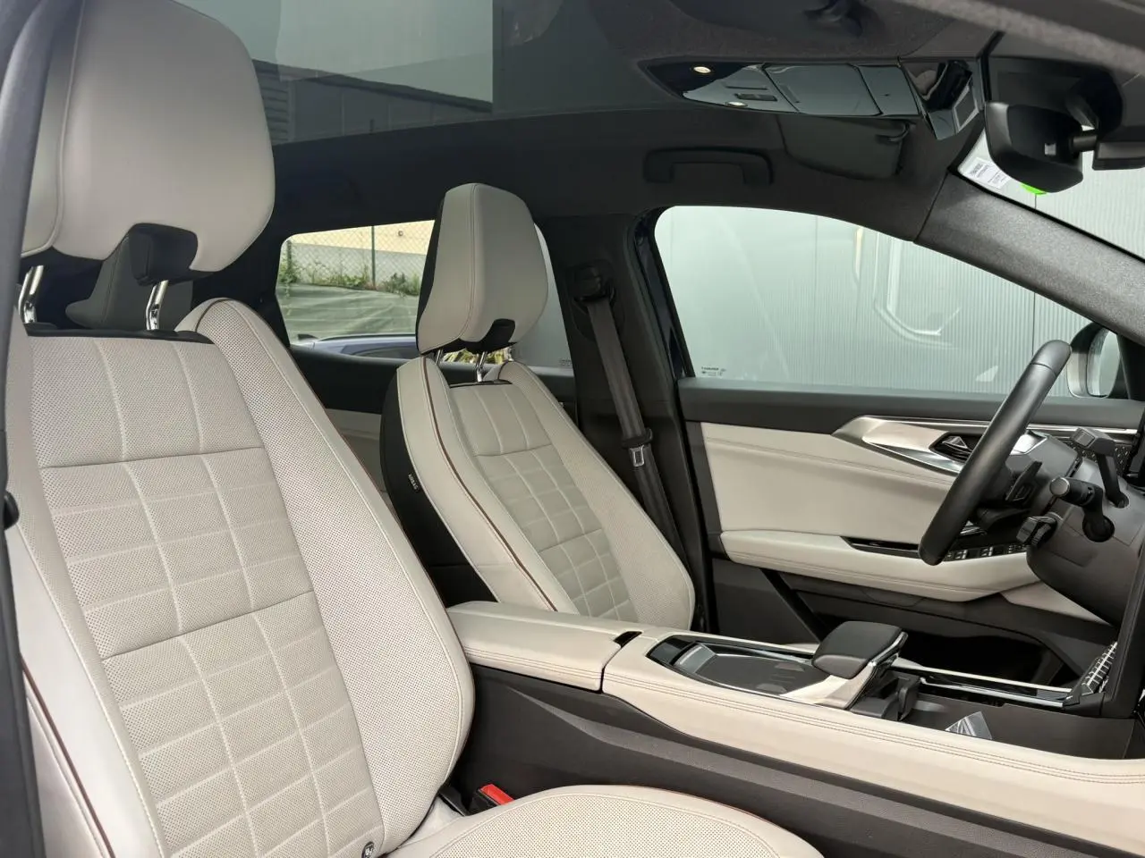 Intérieur du Renault Espace VI 2023, vue côté droit sur sièges cuir gris sable clair et toit panoramique noir.