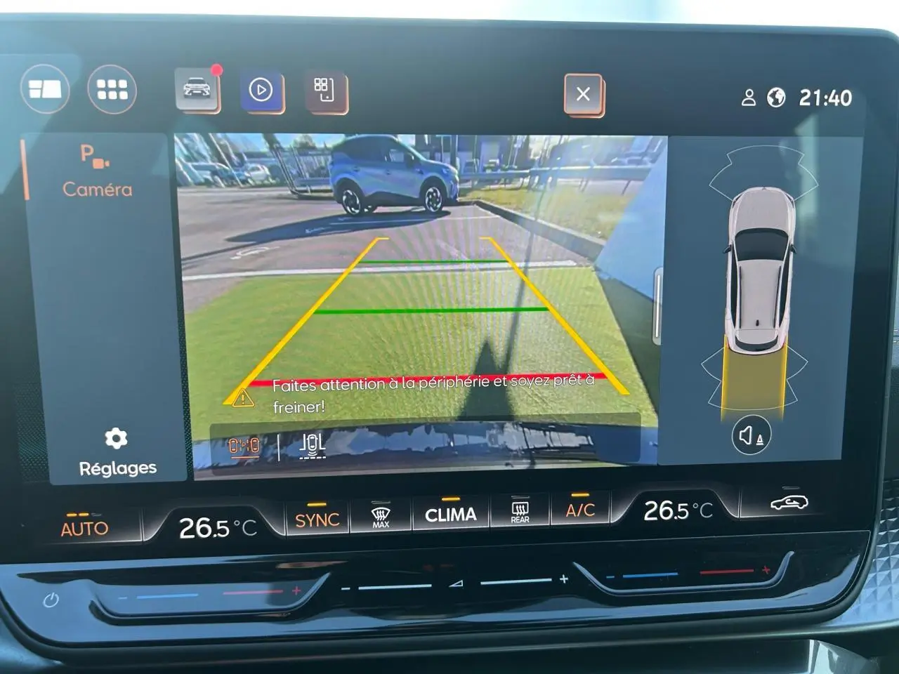 Vue de l'écran caméra de recul du CUPRA Formentor blanc neige avec guidage de stationnement et alertes visibles.
