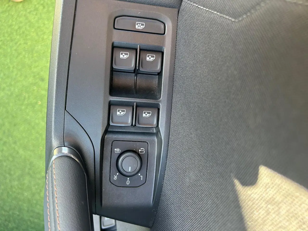 Gros plan sur les commandes de lève-vitres et réglage des rétroviseurs côté conducteur du CUPRA Formentor blanc neige 2025.