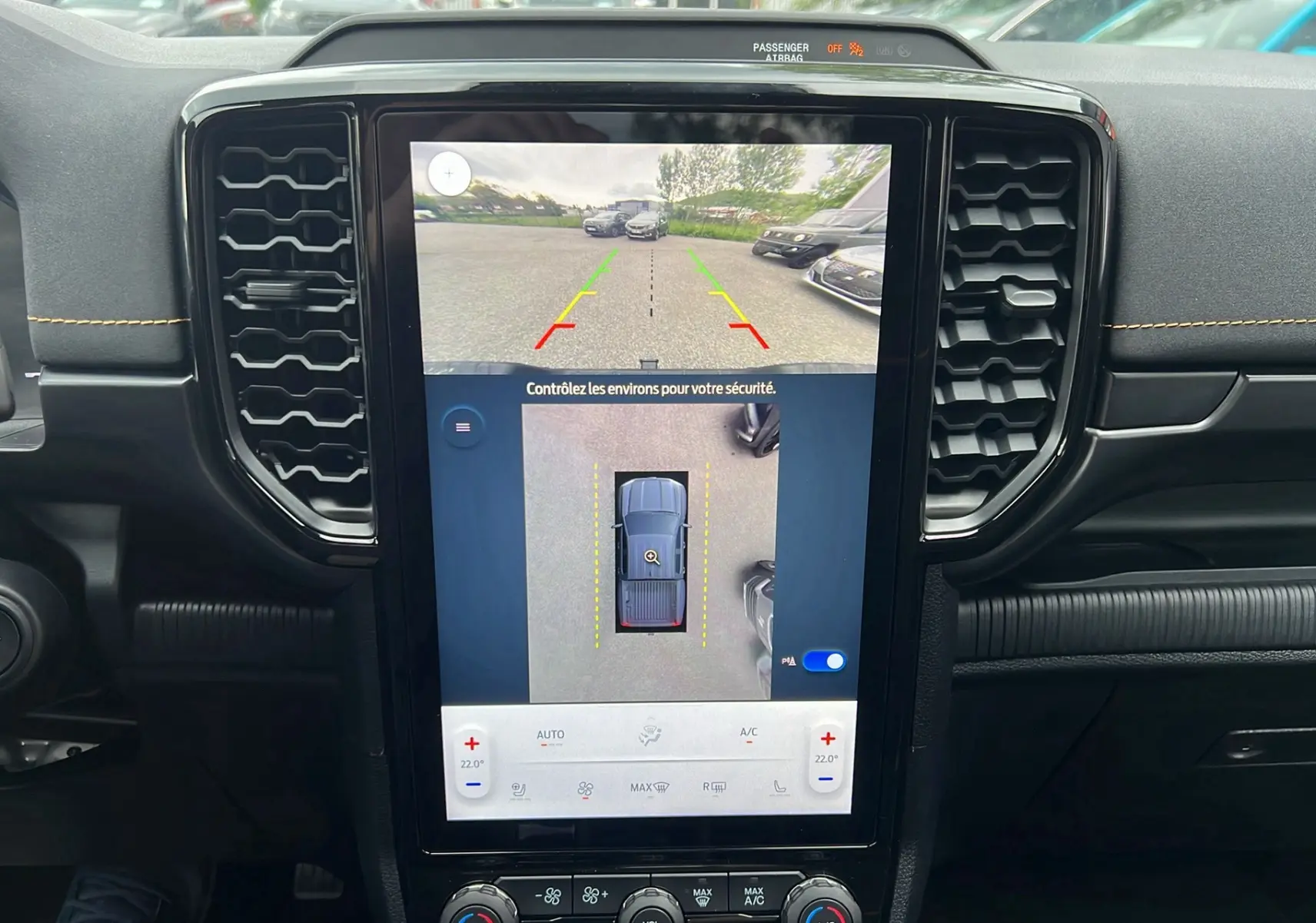 Vue intérieure du tableau de bord du Ford Ranger gris iconic 2025 avec écran tactile affichant la caméra 360° en mode stationnement.