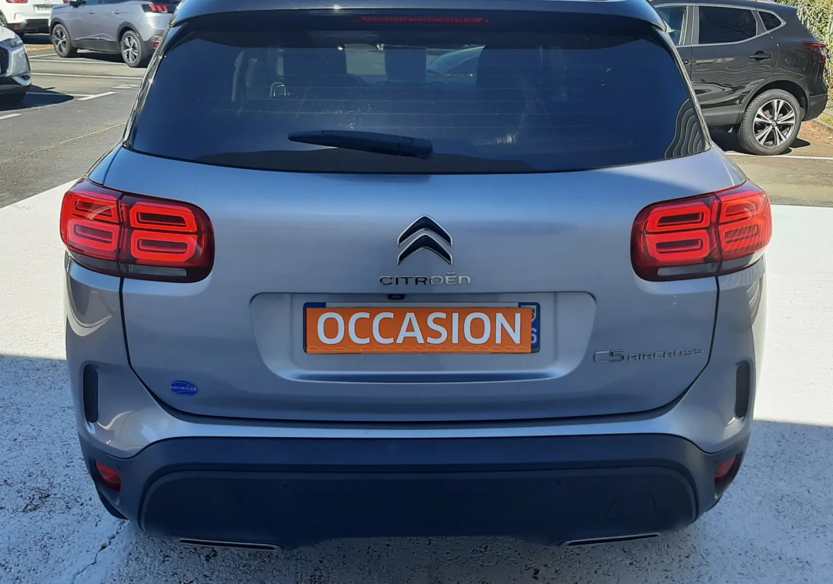 Vue arrière d'un Citroën C5 Aircross gris Artense avec toit noir, feux arrière LED et plaque "OCCASION" visible.