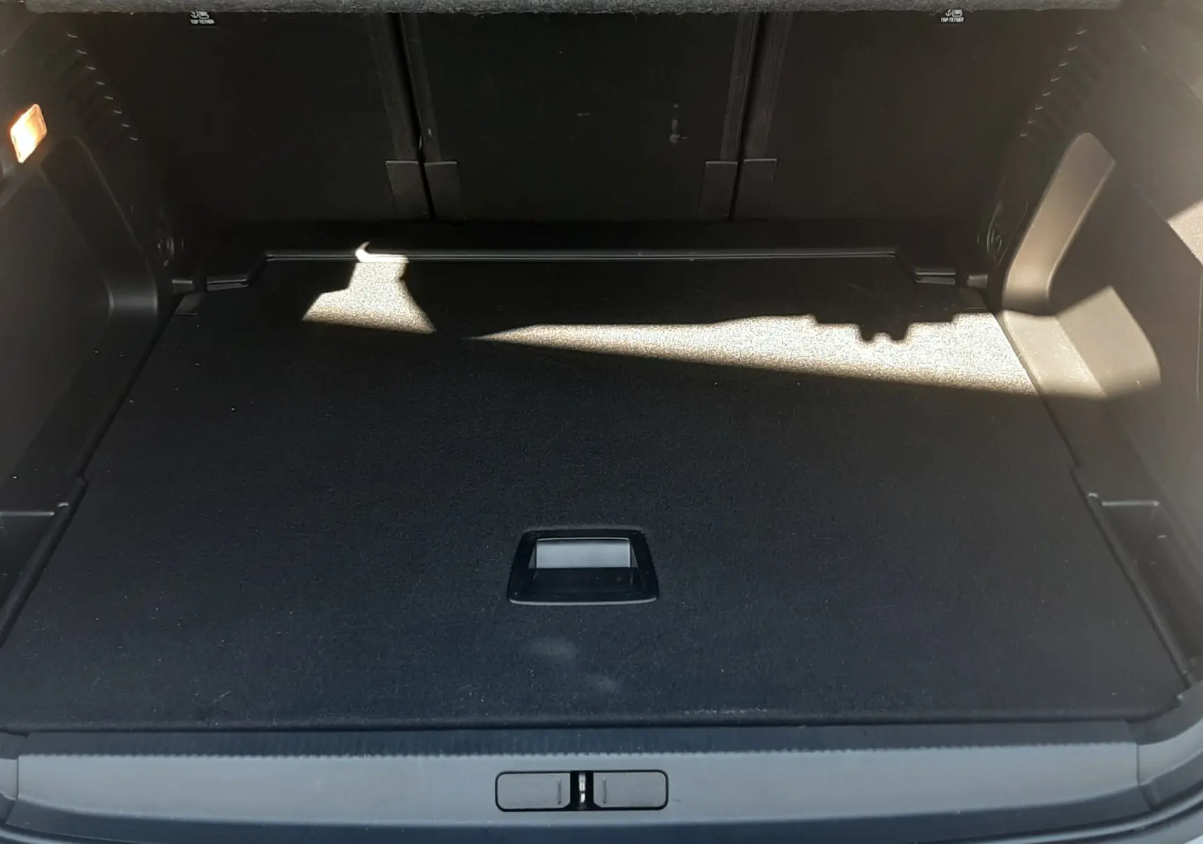 Coffre ouvert vu de l'arrière du Citroën C5 Aircross gris Artense avec toit noir, montrant le plancher plat et l'espace de rangement.