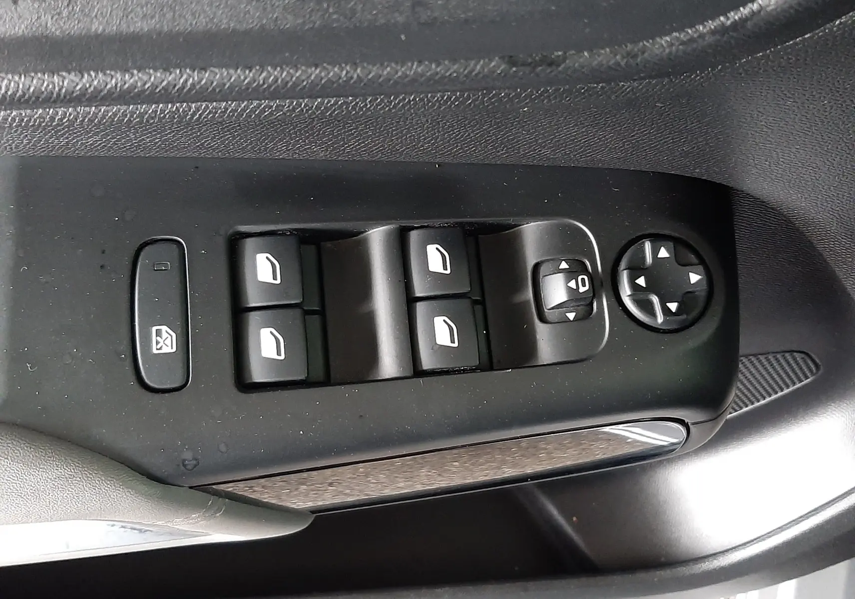 Gros plan sur les commandes des vitres et rétroviseurs côté conducteur d'une Citroën C5 Aircross gris Artense avec toit noir.