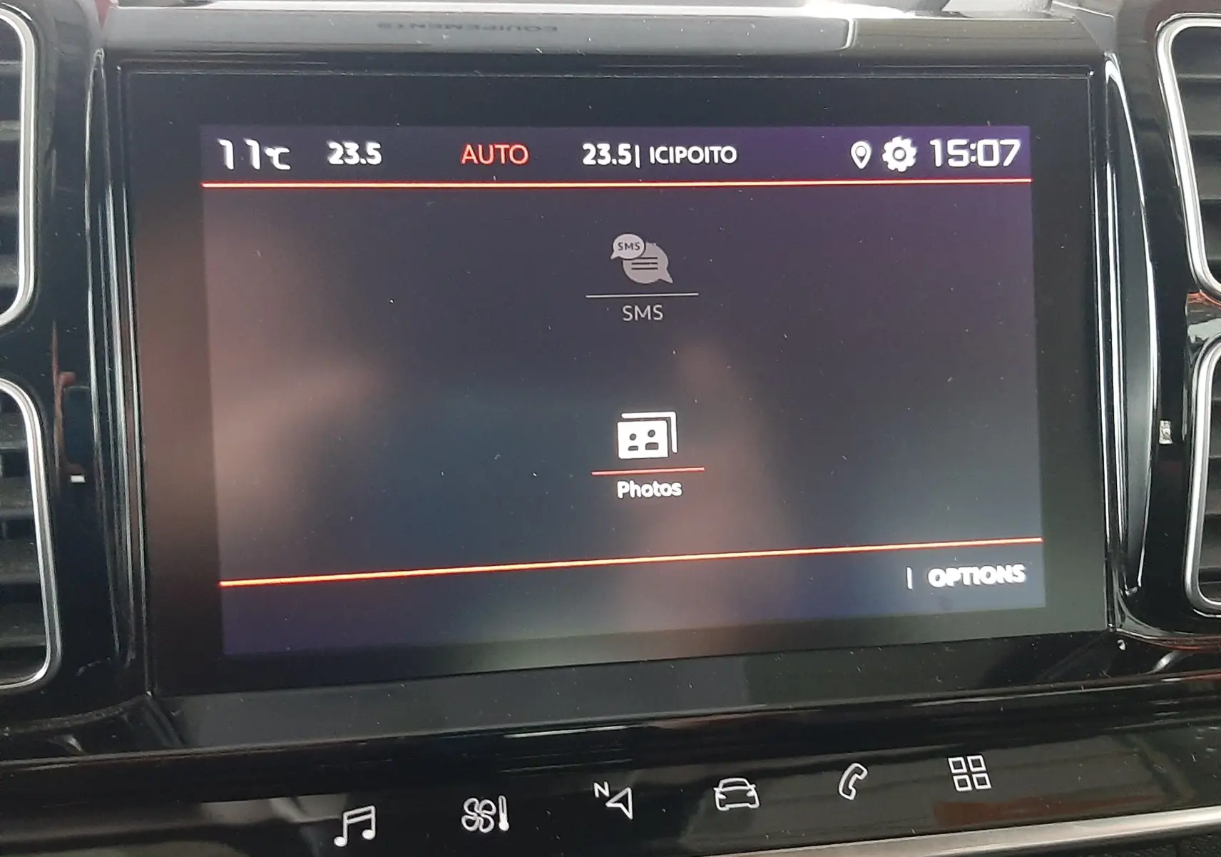 Écran tactile central du tableau de bord du Citroën C5 Aircross 2021 affichant le menu SMS et Photos, vue de face.