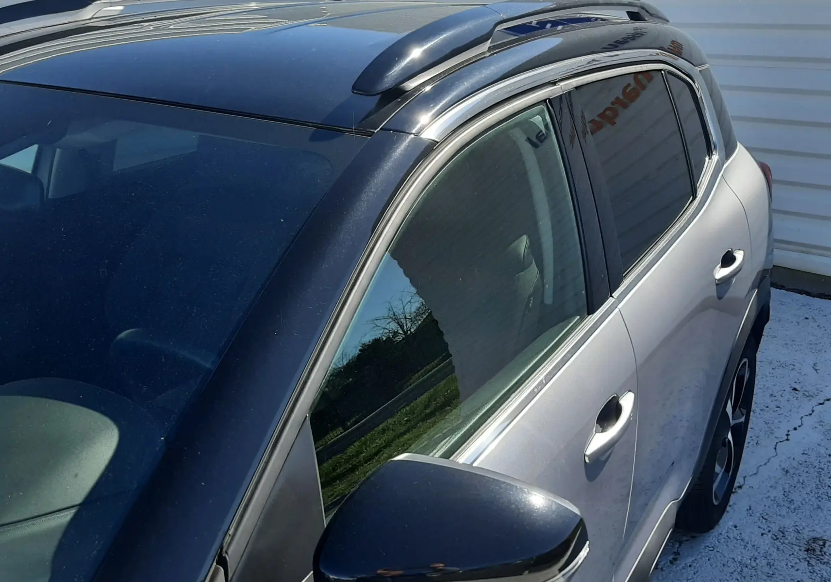 Vue de dessus côté gauche d'un Citroën C5 Aircross gris Artense avec toit noir brillant et rétroviseur noir.