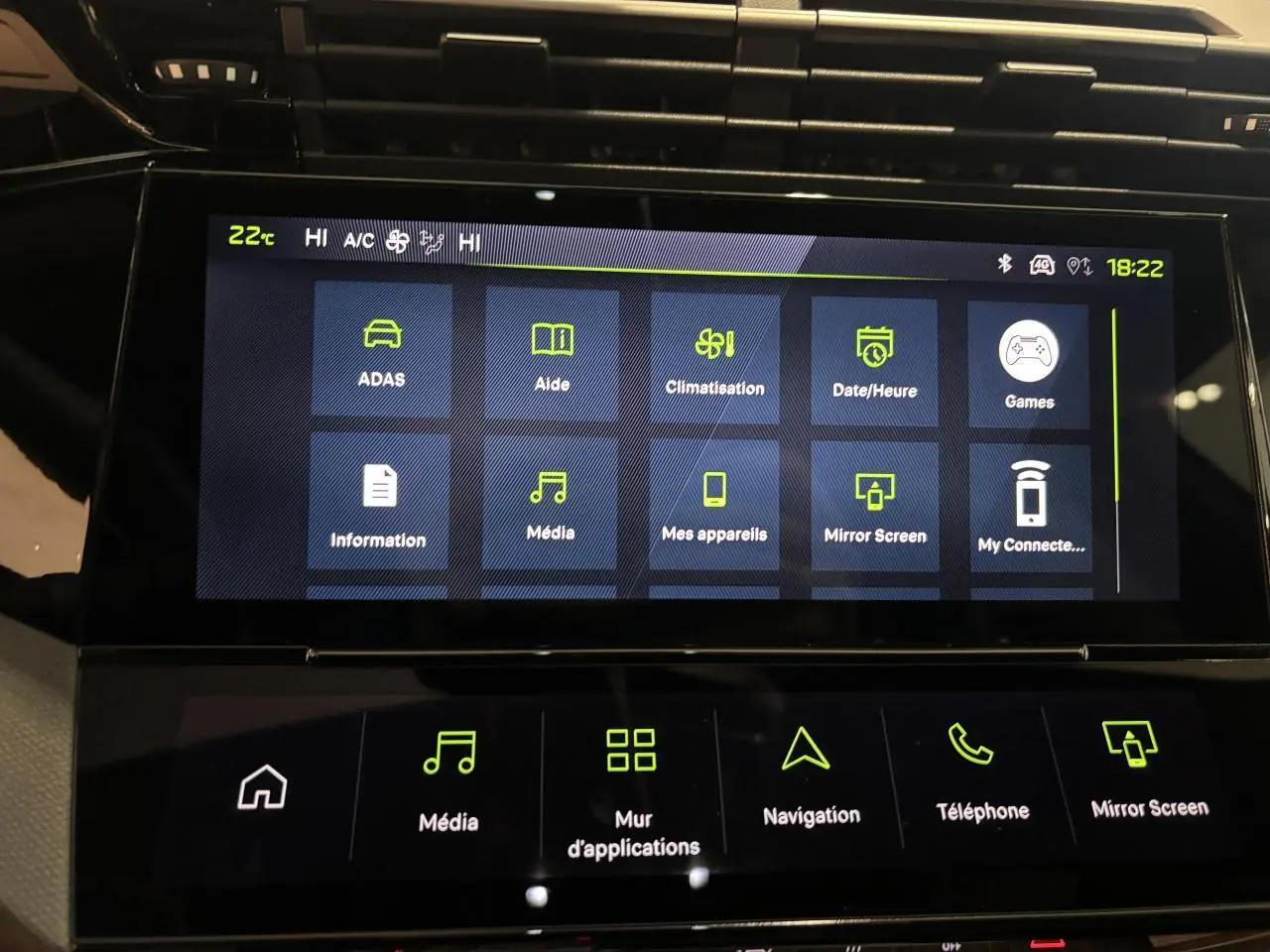 Écran tactile central de la Peugeot 308 hybride blanc Okenite, affichant le menu des applications et réglages multimédia.