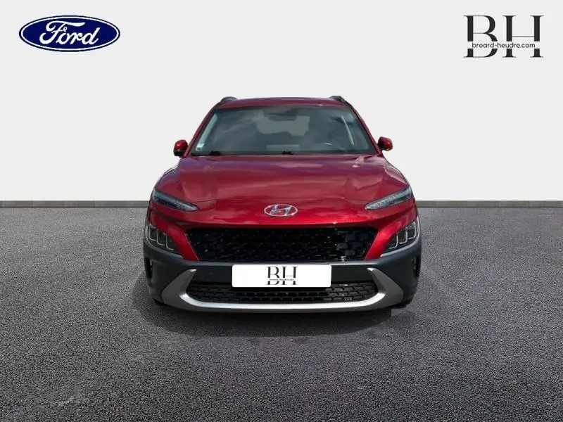 Vue frontale d'un Hyundai Kona 1.6 GDi Hybrid 2021 en rouge Pulse Métal avec calandre noire et détails gris.