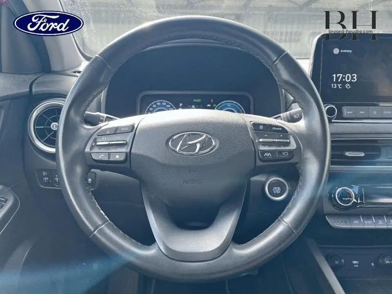 Vue rapprochée du volant cuir multifonction d’un Hyundai Kona 1.6 GDi Hybrid, avec tableau de bord et écran tactile.