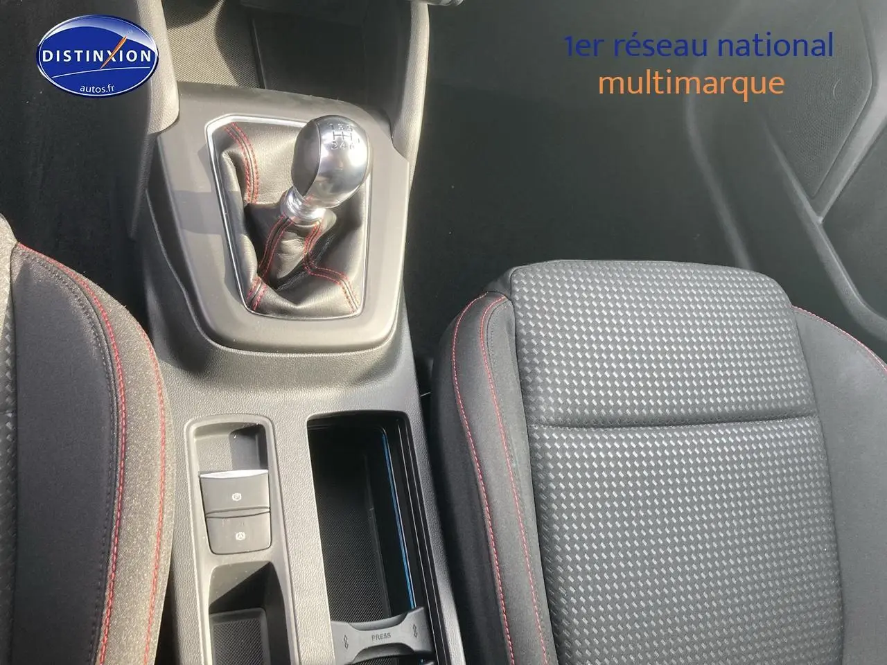 Gros plan sur la console centrale et le siège conducteur gris avec coutures rouges de la Ford Focus ST-Line X 2025.