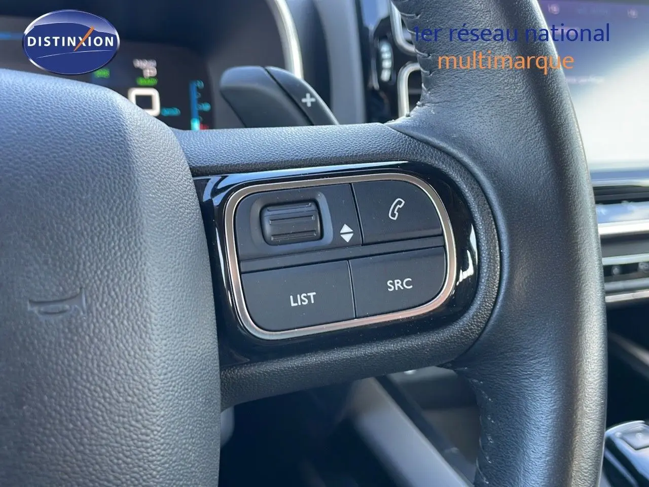 Gros plan sur les commandes gauche du volant cuir noir du Citroën C5 Aircross blanc nacré 2021 hybride.