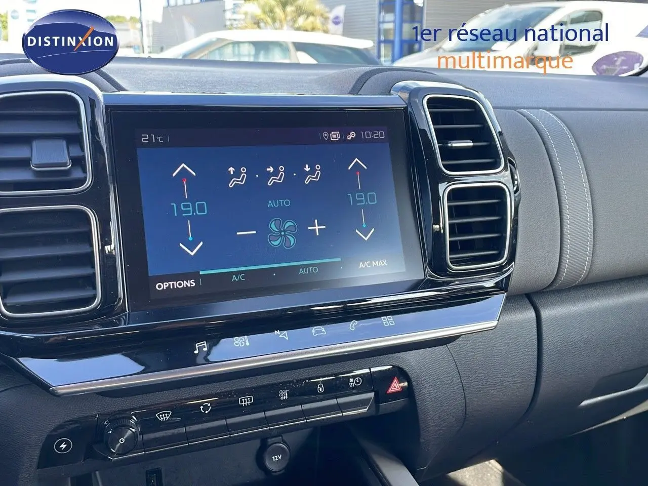 Vue rapprochée de la console centrale du Citroën C5 Aircross blanc nacré, avec écran tactile et commandes de climatisation.